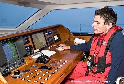 John at the chart table in the enclosed wheelhouse of Jongert sailboat Vivid in Disko Bay, West Greenland