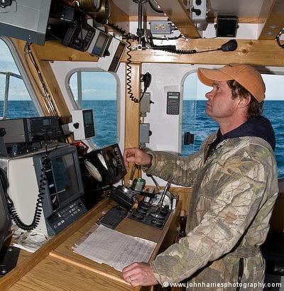 The skipper of a lobster boat off Cape Sable, Nova Scotia judges the wind, tide, water depth, and bottom contours as he manouvres the 45 foot boat into place
