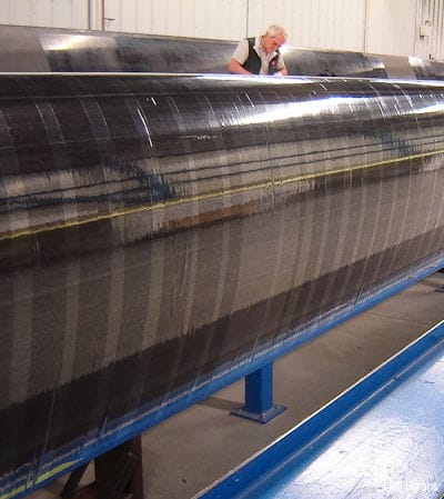 A Hall Spars technician wraps plastic on a carbon fibre mast prior to sending it to the autoclave machine