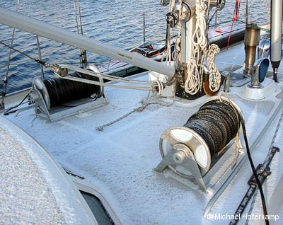 The snow-covered deck of aluminum expedition sailboat Polaris with Easyroll line reels in place
