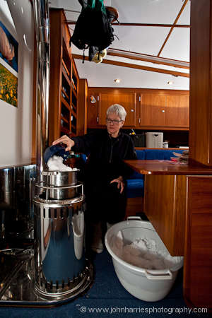 Phyllis melting snow on the Refleks heater on aluminum expedition sailboat Polaris in her winter home at Disko Bay, Greenland
