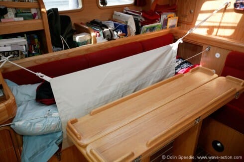 By specifying a right angle at the back of the port hand settee, together with a trotter box to put your feet in, we were able to create a full length berth for tall crew members. The lee cloth is high enough to keep the inhabitant of the berth safe in all conditions, and can be double fastened for extra security.