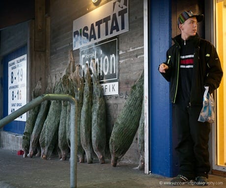 A young Greenlandic man standing outside the grocery store, Aasiaat, West Greenland, Christmas 2009 A young Greenlandic man standing outside the store, which is selling imported Christmas trees, an incongruity we thought in this treeless land. We chatted a bit as he tried out his very good English, learned from movies and computer games.