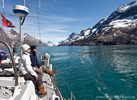 Sitting on the sidedeck of a sailboat, looking at mountains in West Greenland JHH5II-10380