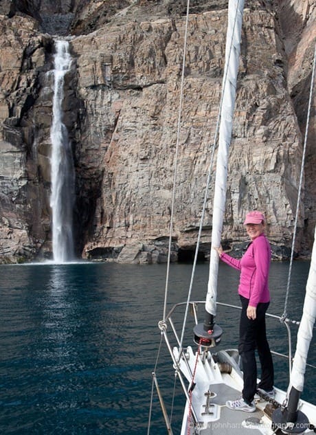 Looking at waterfall from bow of sailboat, West Greenland JHH5II-11364