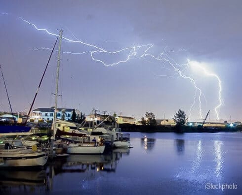 Sailboats in the water with lightning strikes in sky in distance Thunderstorm Lightning Over Thea Foss Waterway Boats Tacoma Wash